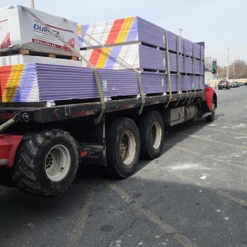 Flatbed with purple sheetrock and Durock pallets