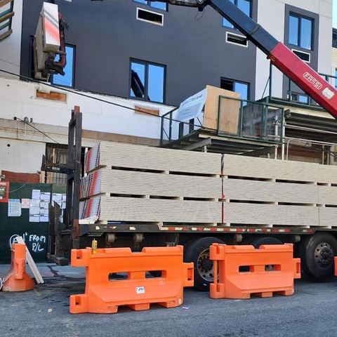 Boom delivery at a job site with traffic barriers